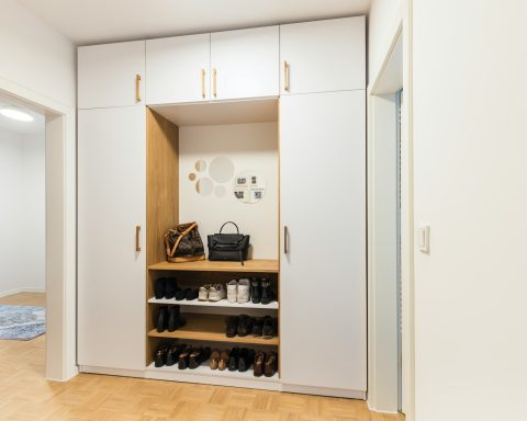 a white closet with a shoe rack and a handbag