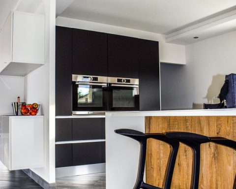 A contemporary kitchen featuring sleek cabinetry and elegant bar stools in a minimalist design.