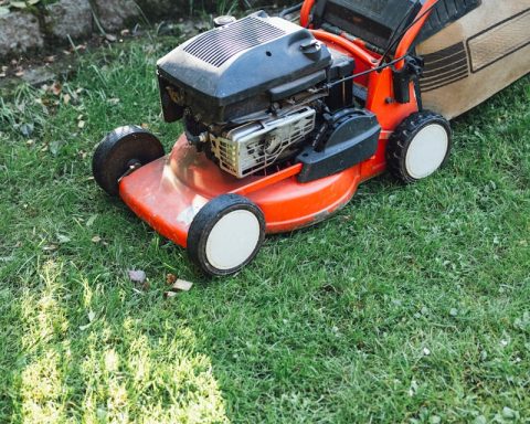 A lawn mower sitting on top of a lush green field