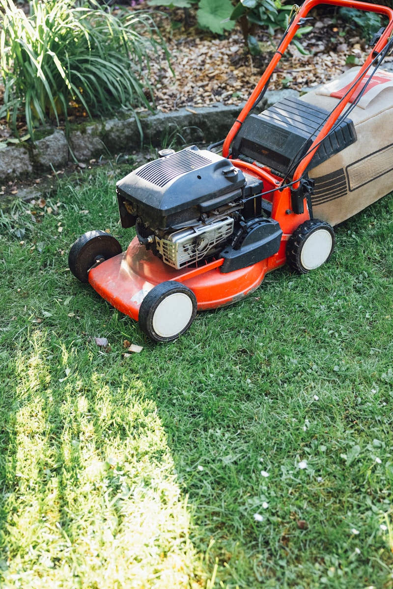 A lawn mower sitting on top of a lush green field