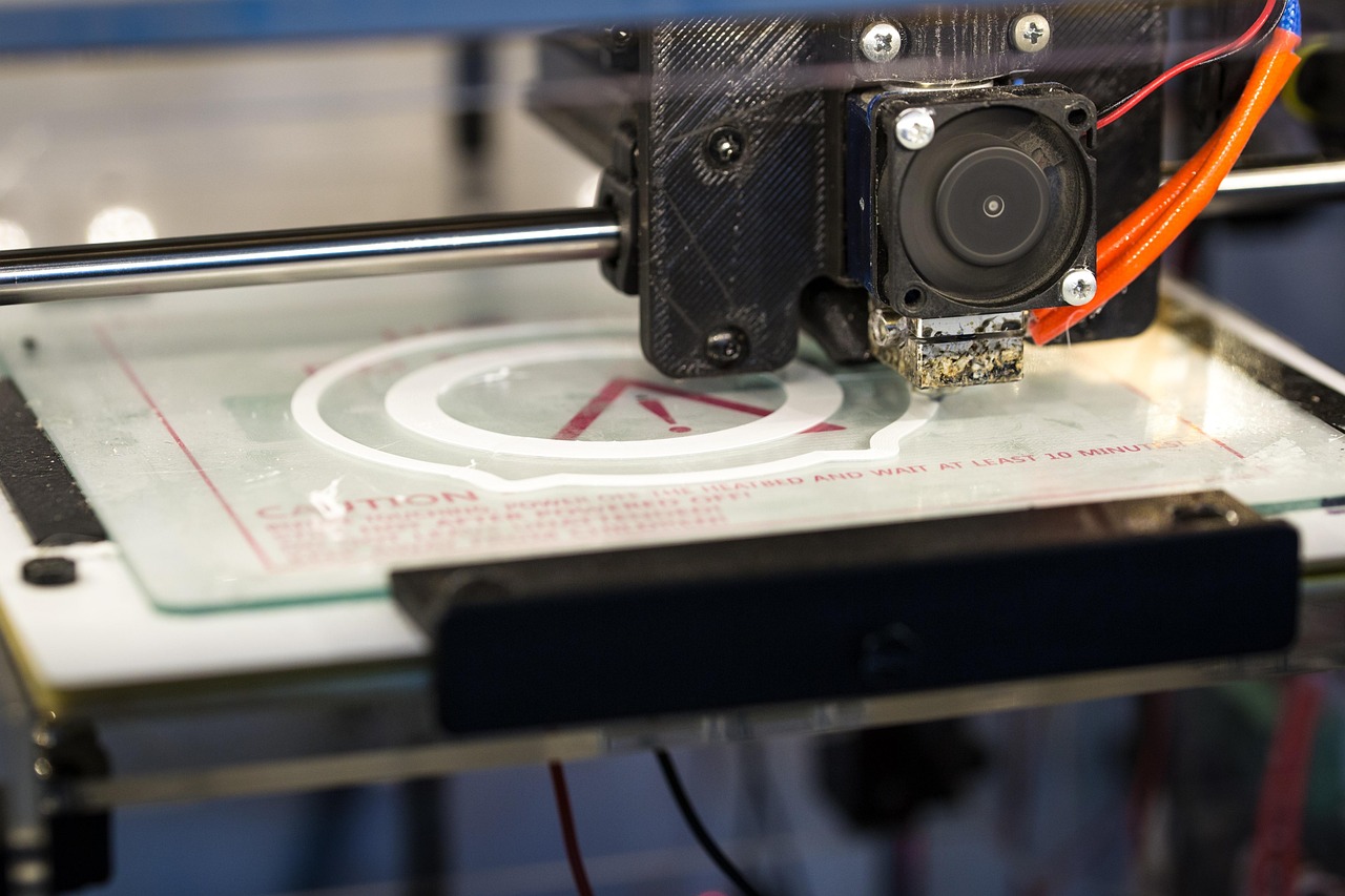Een FDM 3D-printer met een kleurrijke filamentspoel op de achtergrond
