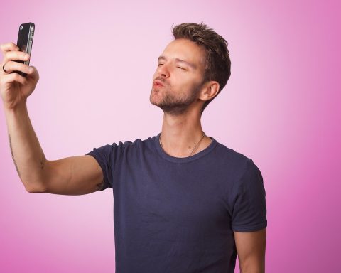 Man die op zijn smartphone een dating-app bekijkt
