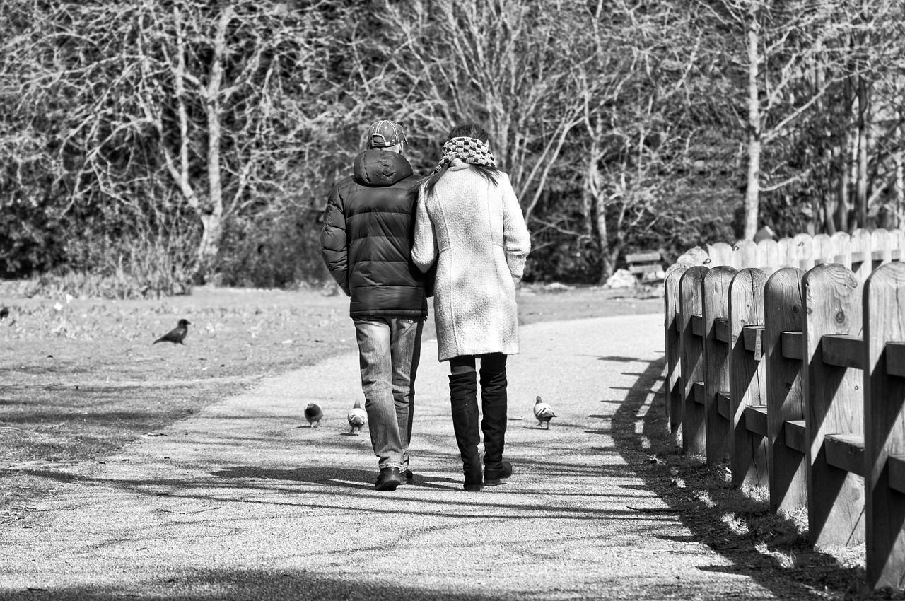 Twee mannen wandelen naast elkaar door een park tijdens een gesprek