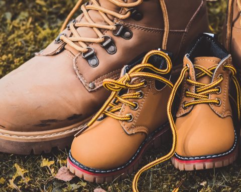 Bruin lederen chelsea boots op een houten vloer