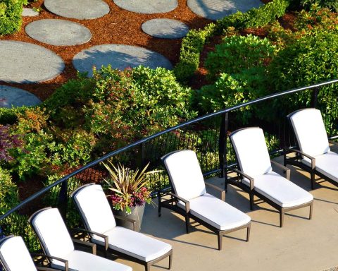 Een ligbed met textilene mat op een terras in de tuin